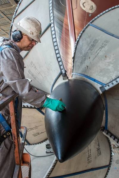 Lindell Toombs, a Newport News shipbuilder with 41 years of experience, applies a protective coating to one of the four propellers on the aircraft carrier Gerald R. Ford (CVN 78). Photo by Chris Oxley