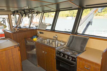 The utilitarian galley is also in the wheelhouse along with a mess table and two bunks